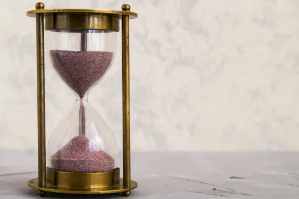 An image of an hourglass placed on a table.