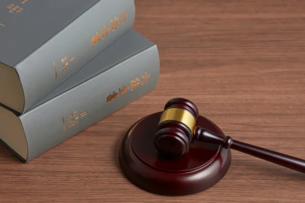 An image of books and a wooden gavel on a table.